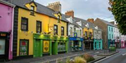 Colorful buildings line a street under a cloudy sky