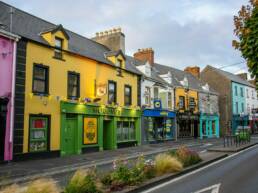 Colorful buildings line a street under a cloudy sky